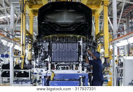 Workers Assembles Cars At Automobile Assembly Line Production Plant