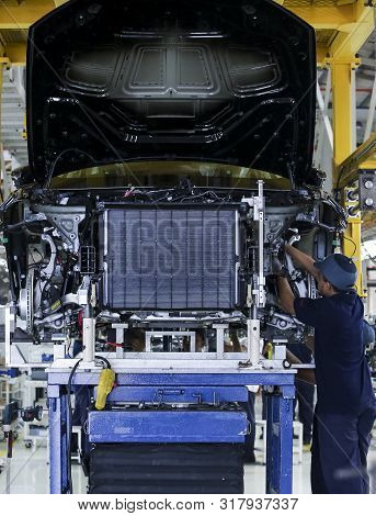 Workers Assembles Cars At Automobile Assembly Line Production Plant