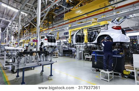 Workers Assembles Cars At Automobile Assembly Line Production Plant