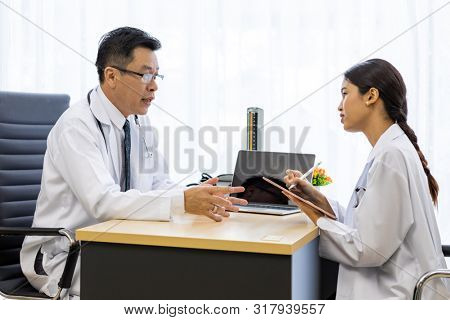 Two doctors in the hospital discuss the diagnos of the patient
