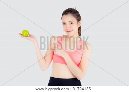 Beautiful Portrait Young Asian Woman In Sport With Satisfied And Holding And Pointing Green Apple Is