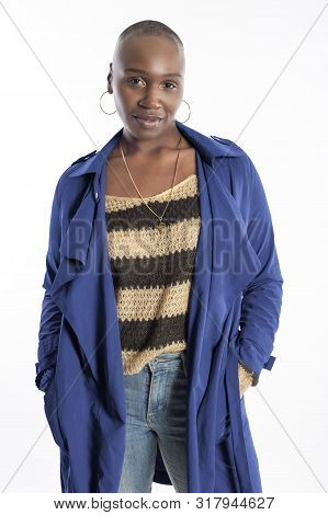 Black African American Fashion Model With Bald Hairstyle Confidently Posing With A Vibrant Blue Colo