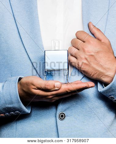 Men Perfumes. Fashion Cologne Bottle. Man Holding Up Bottle Of Perfume. Men Perfume In The Hand On S