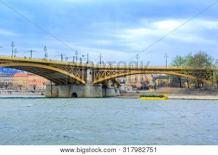 Budapest, Hungary Bridge And Water Bus Or Amphibian Transport At Danube River And City Background