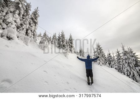 Back View Of Tourist Hiker Standing With Raised Arms On Steep Mountain Slope On Copy Space Backgroun