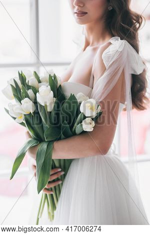Wedding Bouquet Of White Tulips In The Hands Of A Beautiful Bride. Soft Focus
