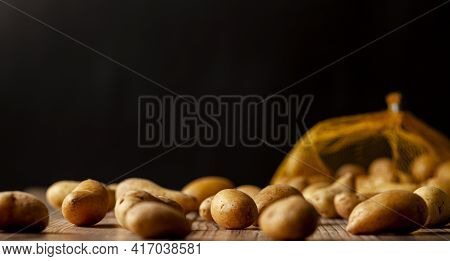 Shallow Depth Of Field Dark Image Of Small Irregular Shaped Ratte Potatoes Scattered On The Surface 