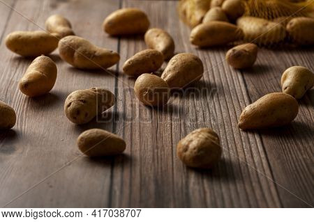 Shallow Depth Of Field Dark Image Of Small Irregular Shaped Ratte Potatoes Scattered On The Surface 