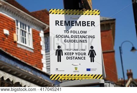 TENTERDEN, ENGLAND - APRIL 4, 2021: A Coronavirus social distancing warning sign in the High Street at Tenterden in Kent.