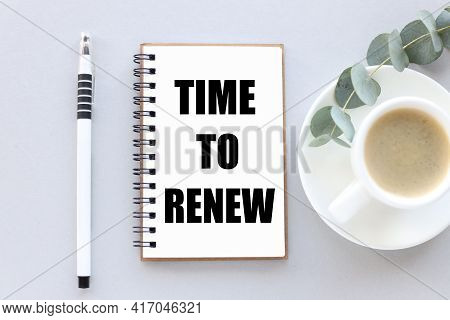 Time To Renew . Text On White Notepad Paper. Near Cups With Coffee And Plants On A Gray Background.