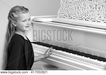 Beautiful Little Girl Playing On White Grand Piano