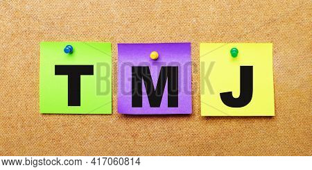 On A Beige Background, Multi-colored Stickers For Notes With The Word Tmj