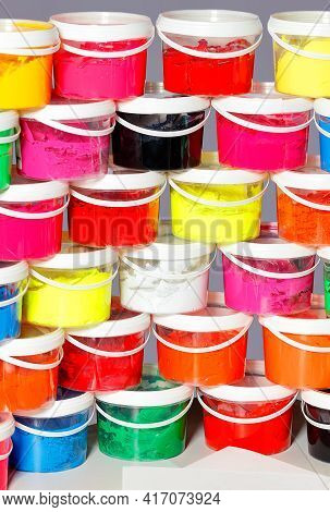 Screen Printing Inks In A Variety Of Vibrant Colors Are Stacked In Clear Plastic Containers On Top O