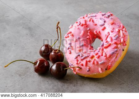 1 Pink Donat, Fresh Cherries On A Gray Background