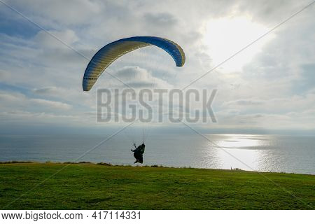 Man Doing Sport, Para-glider In The Clouded Sky. Paragliding Is An Extreme Sport And Recreation. Tor