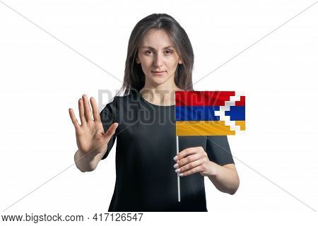 Happy Young White Woman Holding Flag Of Nagorno-karabakh Republic And With A Serious Face Shows A Ha
