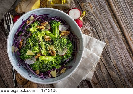 Plate With A Healthy Vegetarian Salad Of Steamed Broccoli, Fresh Radishes, Walnuts, Red Cabbage, Gin