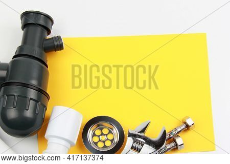A Set Of Plumbing Accessories And Tools For Installing A Sink Siphon On A White-yellow Background. T