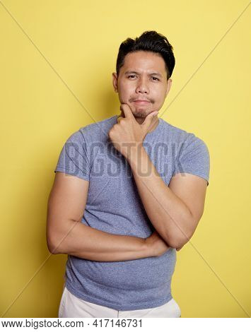 Casual Young Man Smile Thinking Idea With Holding The Chin And One Hand On Stomach