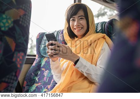 Muslim Woman Using Her Mobile Phone While Riding A Bus