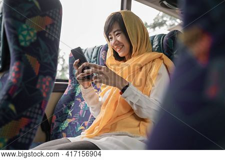 Muslim Woman Using Her Mobile Phone While Riding A Bus