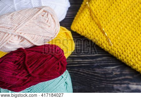 Skeins Of Colored Yarn And Knitting On A Dark Wooden Background Needlework On A Background Of Self-i