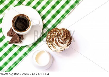 Dark Chocolate And Cocoa Chocolate Cupcakes With A Cup Of Hot Black Coffee On Green Napkin. Space Fo