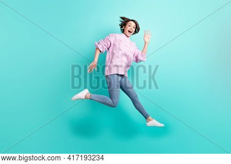 Full Length Photo Of Shiny Excited Young Lady Dressed Purple Pullover Jumping Waving Arm Isolated Te