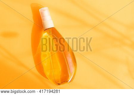 Suntan Oil On An Orange Background .shadows And Light. Protect Your Skin From The Sun. A Proper And 