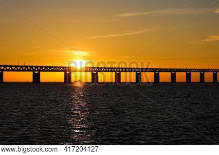 Sunset With The Sun Over And Through A Section Of The Oresund Bridge At The Viewpoint Near Limhamn, 