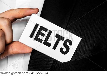 Inscription Ielts International English Language Testing System On A White Business Card. A Man In A