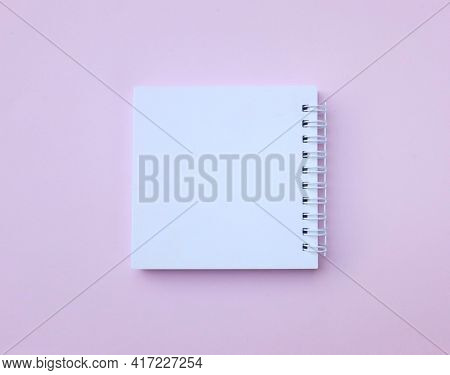 Flat Lay And Top View Blank White Spiral Notepad On A Desk Pink Background.eucation And Business Con