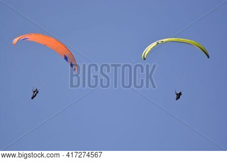 Two Paragliders On The Blue Sky In The Sunshine