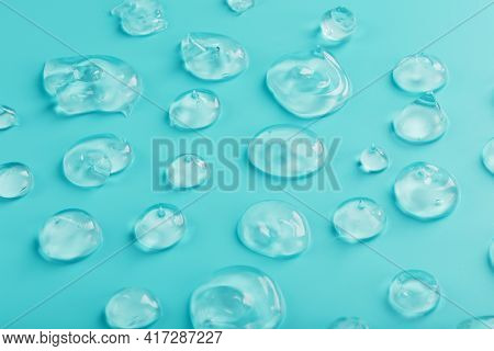 Drops Of Gel With Hyaluronic Acid In The Form Of A Smear Of Glossy Texture On A Cyan Background.