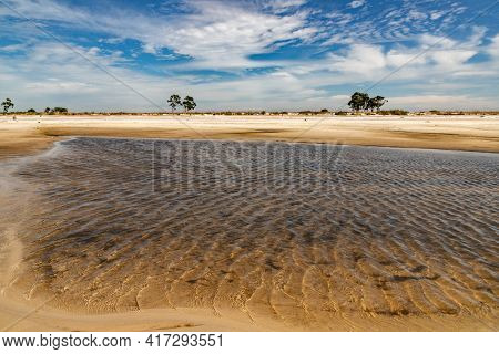 Sand, Clouds And Lake With Blue Sky