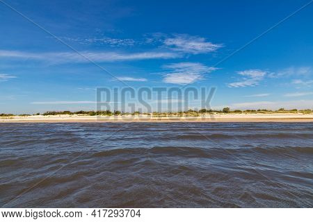 Sand And Lake With Blue Sky