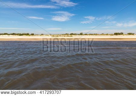 Sand And Lake With Blue Sky