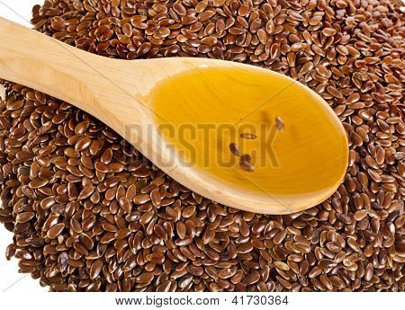 เมล็ด flax เมล็ดและช้อนน้ำมัน closeup บนพื้นหลังสีขาว