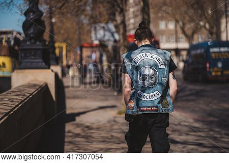 Westminster, London | Uk -  2021.04.17: Man In Jeans West With Black Label Society Sign Walking Down