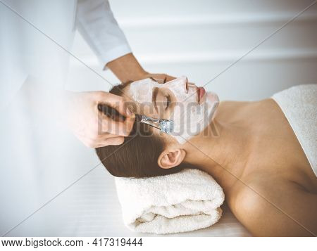 Beautiful Brunette Woman Enjoying Applying Cosmetic Mask With Closed Eyes Comfortable And Blissful. 
