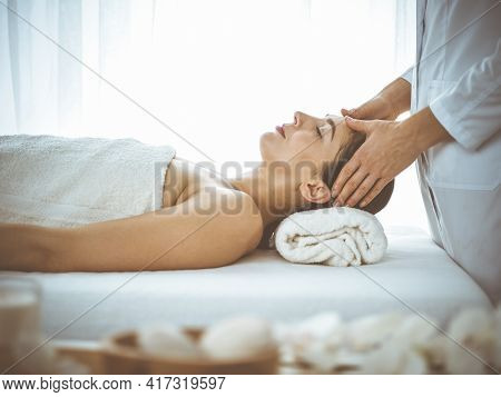 Beautiful Brunette Woman Enjoying Facial Massage With Closed Eyes Comfortable And Blissful. Relaxing