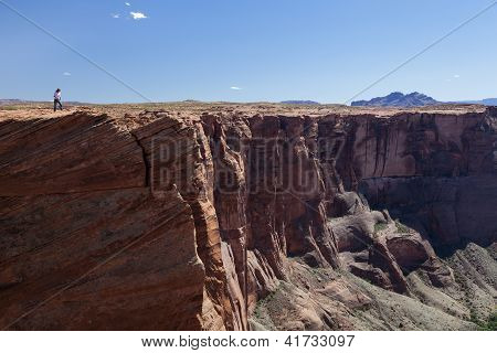 Homem olhando para baixo de uma parede Vertical Canyon