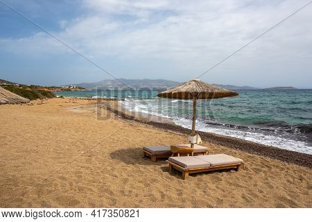Sun Beds And Umbrellas At Soros Beach On Antiparos Island. A Wonderful Beach With The Golden Sand An