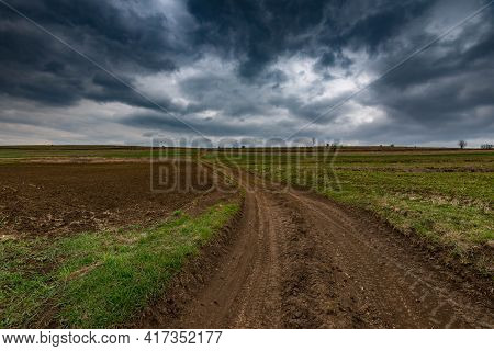 Dirt Road Leading To The Top Of The Hill, Dramatic Stormclouds At Early Spring.
