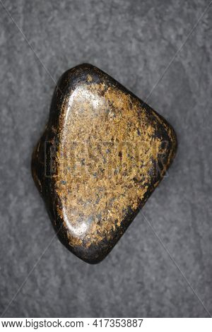 Bronzite Jewel Stone Texture On Black Stone Background. Macro Closeup.
