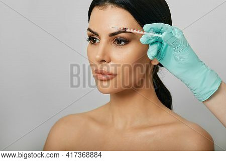 Botulinum Toxin Injections Near A Womans Forehead For Blocking Mimic Wrinkles And Wrinkles Removal. 