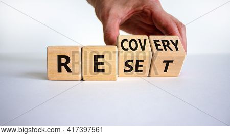 Recovery And Reset Symbol. Businessman Turns Cubes And Changes The Word 'recovery' To 'reset'. Beaut