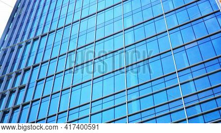 Abstract Closeup Of The Glass-clad Facade Of A Modern Building Covered In Reflective Plate Glass. Ar