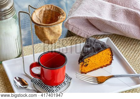 Carrot Cake With Chocolate Icing, Accompanied By A Cup Of Coffee