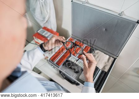 An Adjustable Axis Trial Frame Is Being Held By A Doctor